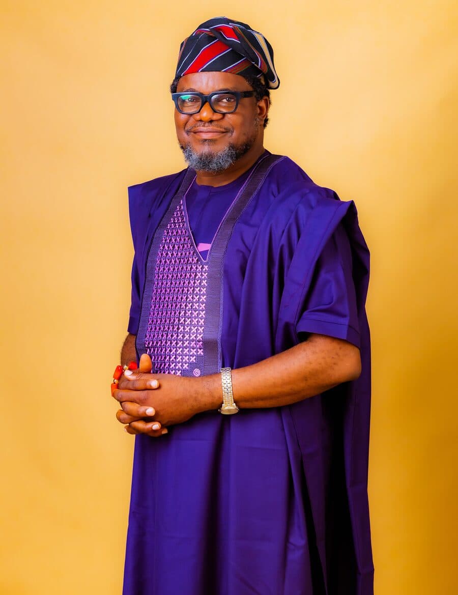 Dr. Olarewaju in traditional purple agbada and cap
