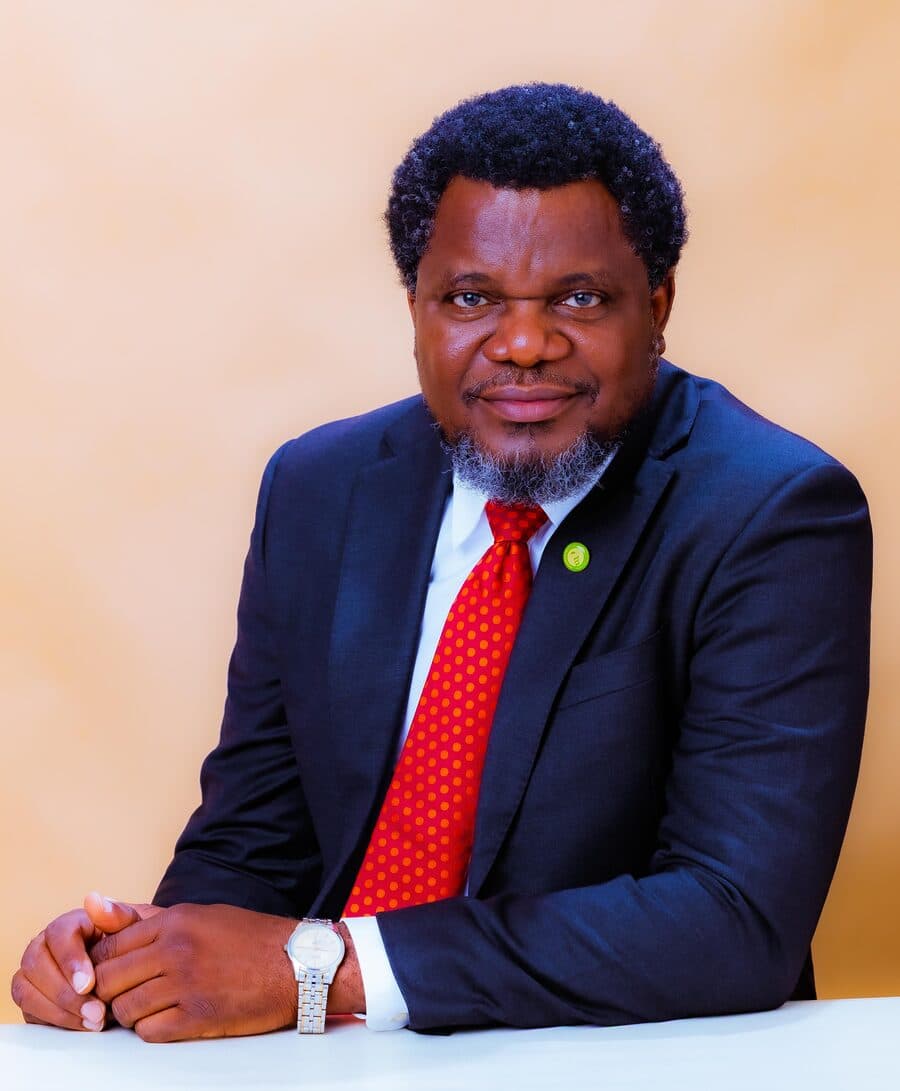 Dr. Olarewaju seated at a table, hands clasped, ready to work