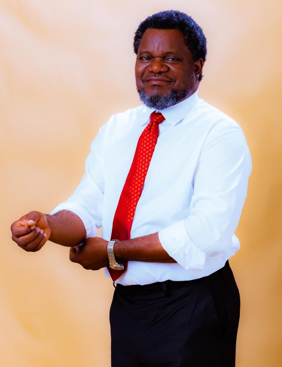 Dr. Olarewaju in a white shirt rolling up his sleeves